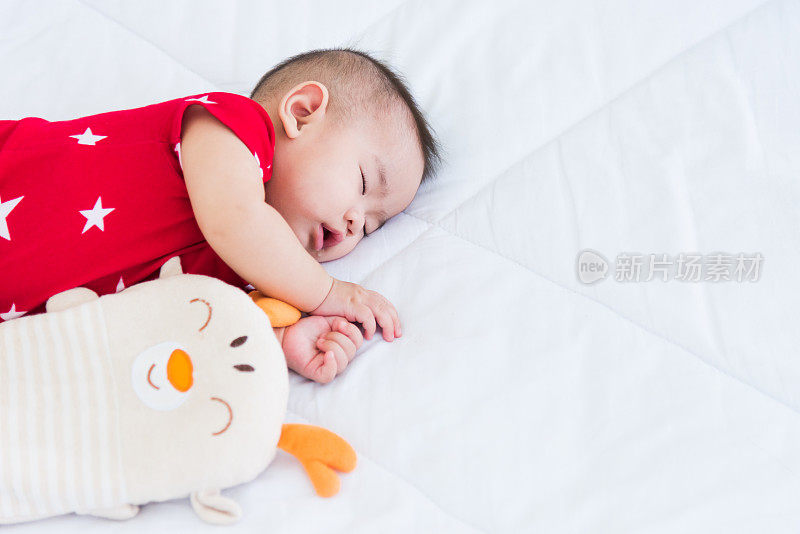 newborn little baby sleeping on white bed at home